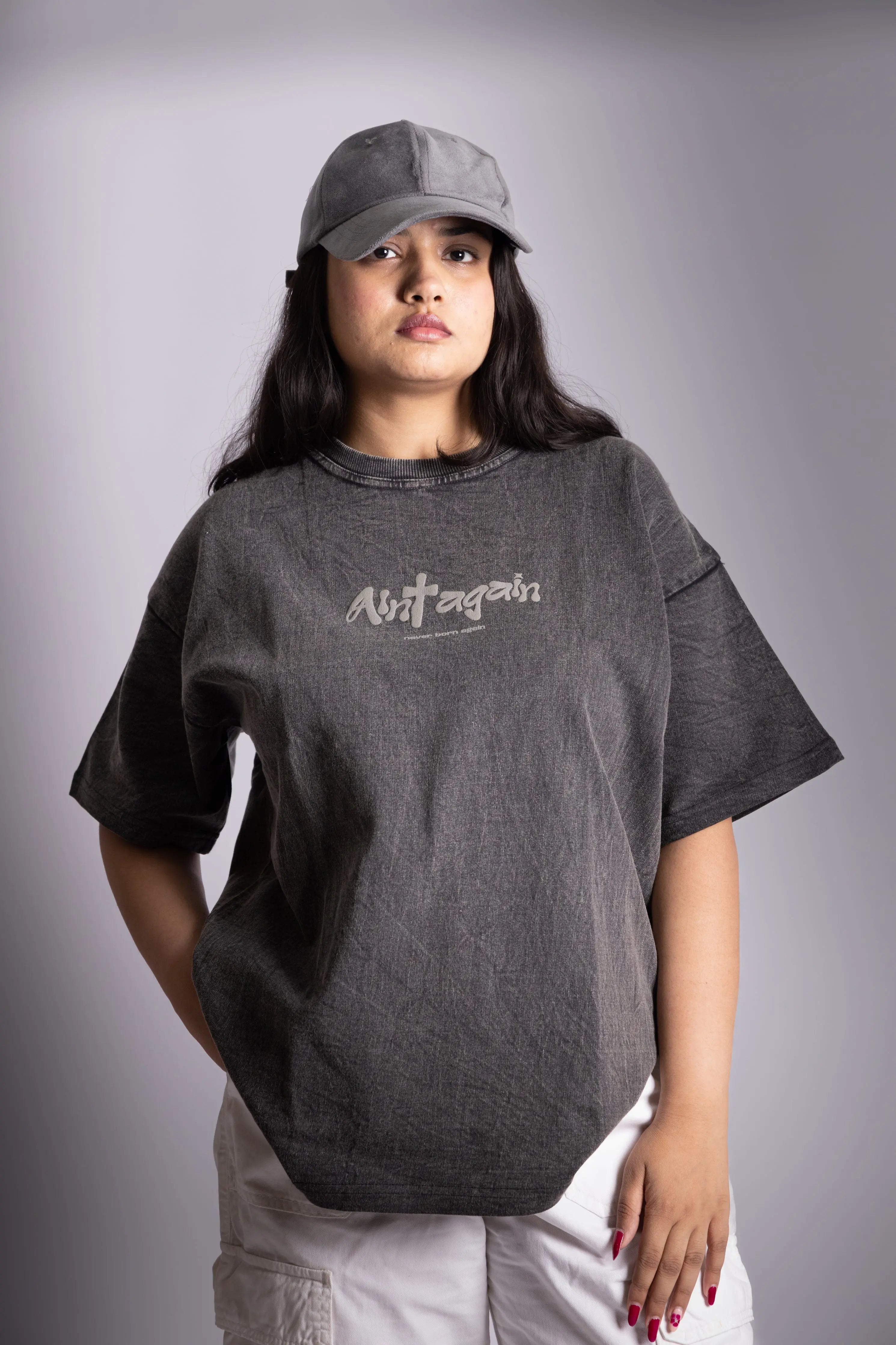 A woman wearing stonewash black oversized T-shirt showing the front puff print.
