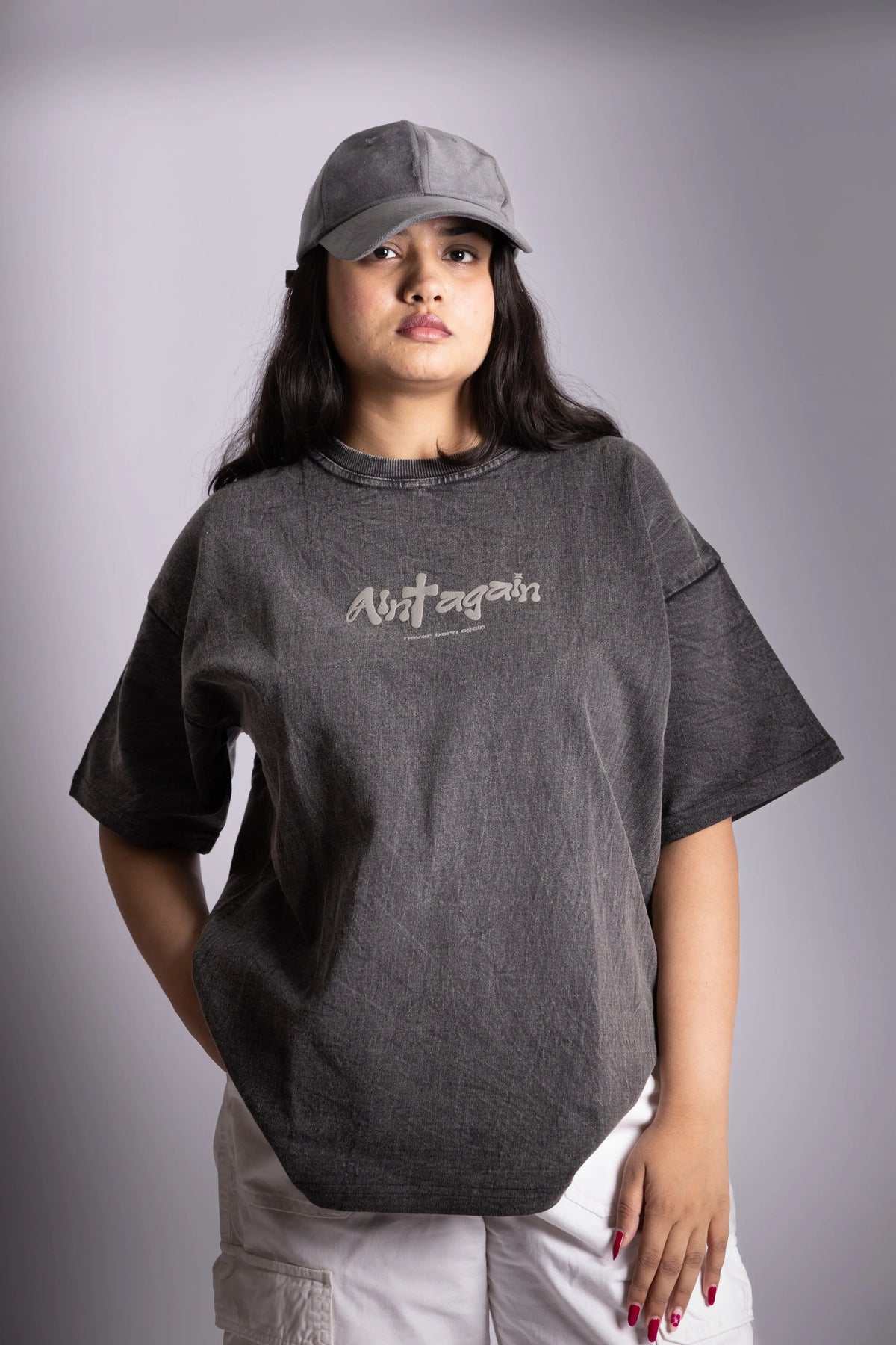 A woman wearing stonewash black oversized T-shirt showing the front puff print.