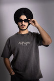 A man wearing stonewash black oversized t-shirt showing the front puff text design