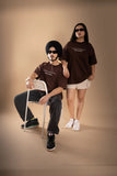 A woman and a man wearing brown oversized T-shirt showing the front print .  
