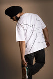 A man wearing white oversized T-shirt showing the screen print back.
